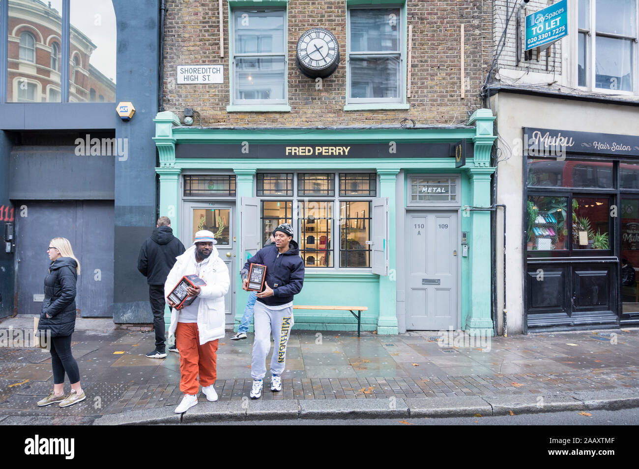 Fred Perry des passants sur Shoreditch High Street, London, London, E1, UK Banque D'Images