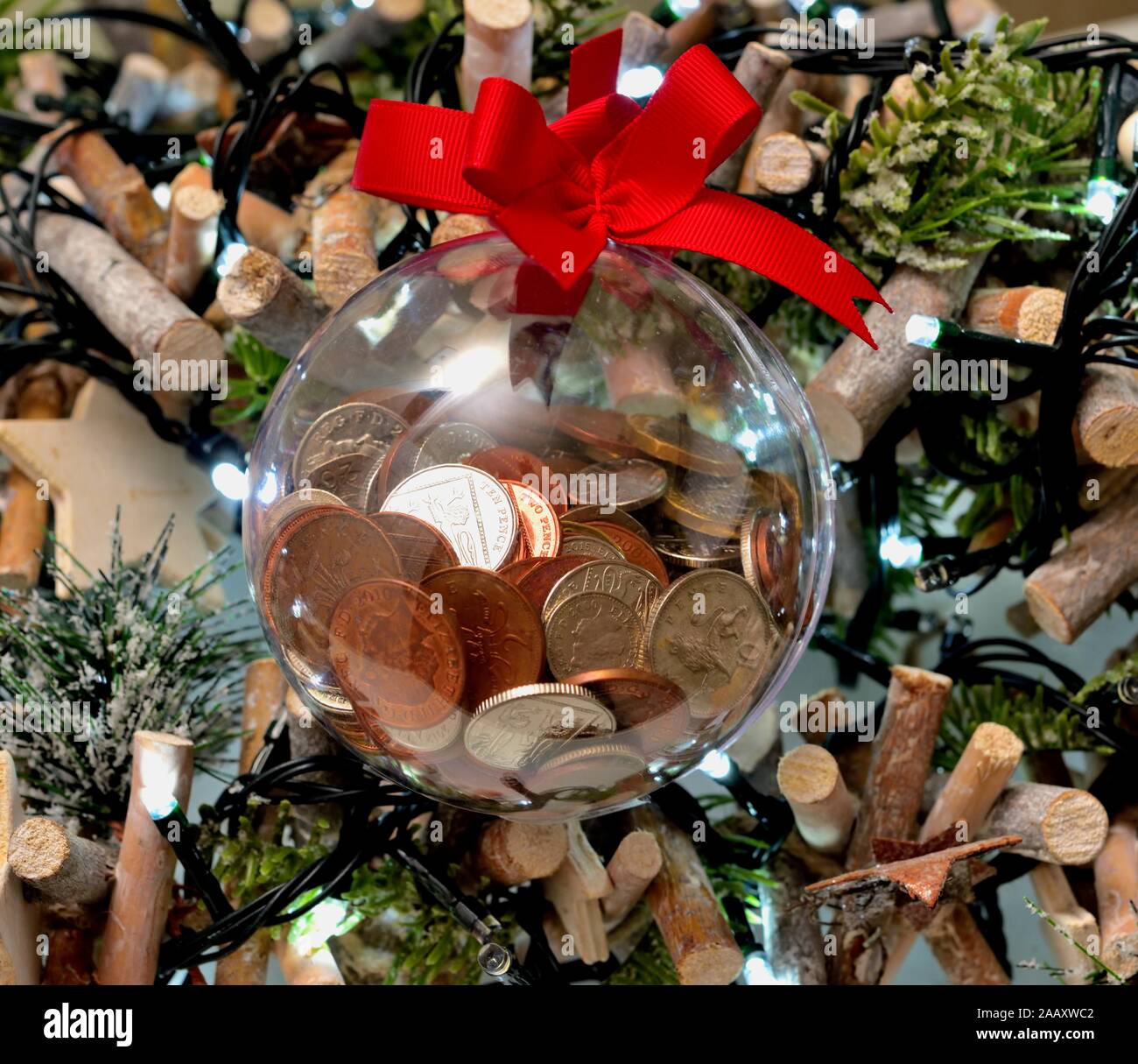 Un changement lâche,argent,cash, dans une boule de noël sur un arbre. Banque D'Images