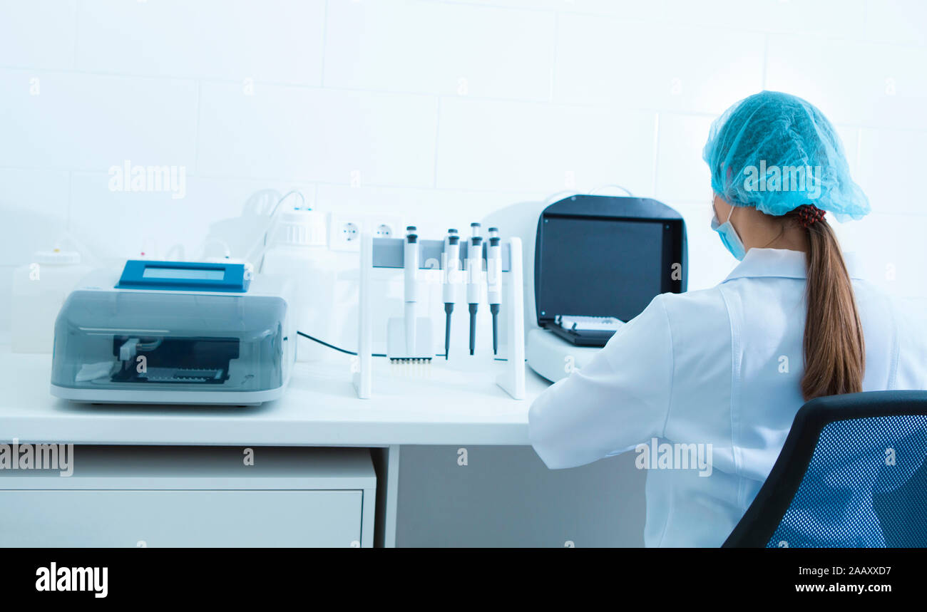 Les jeunes filles en vêtements médicaux travaillant avec des équipements de laboratoire modernes Banque D'Images