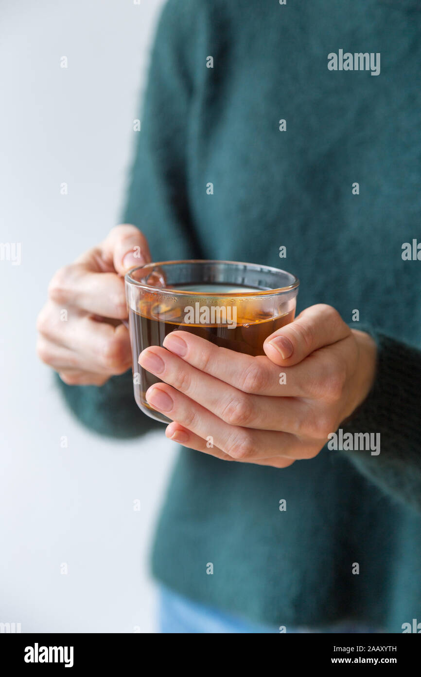 Plateau en verre tasse in women's hands avec pas de manucure. Concept de la photo pour l'humeur d'hiver douillet Banque D'Images Plateau en verre tasse in women's hands avec pas de manucure. Concept de la photo pour l'humeur d'hiver douillet Banque D'Images