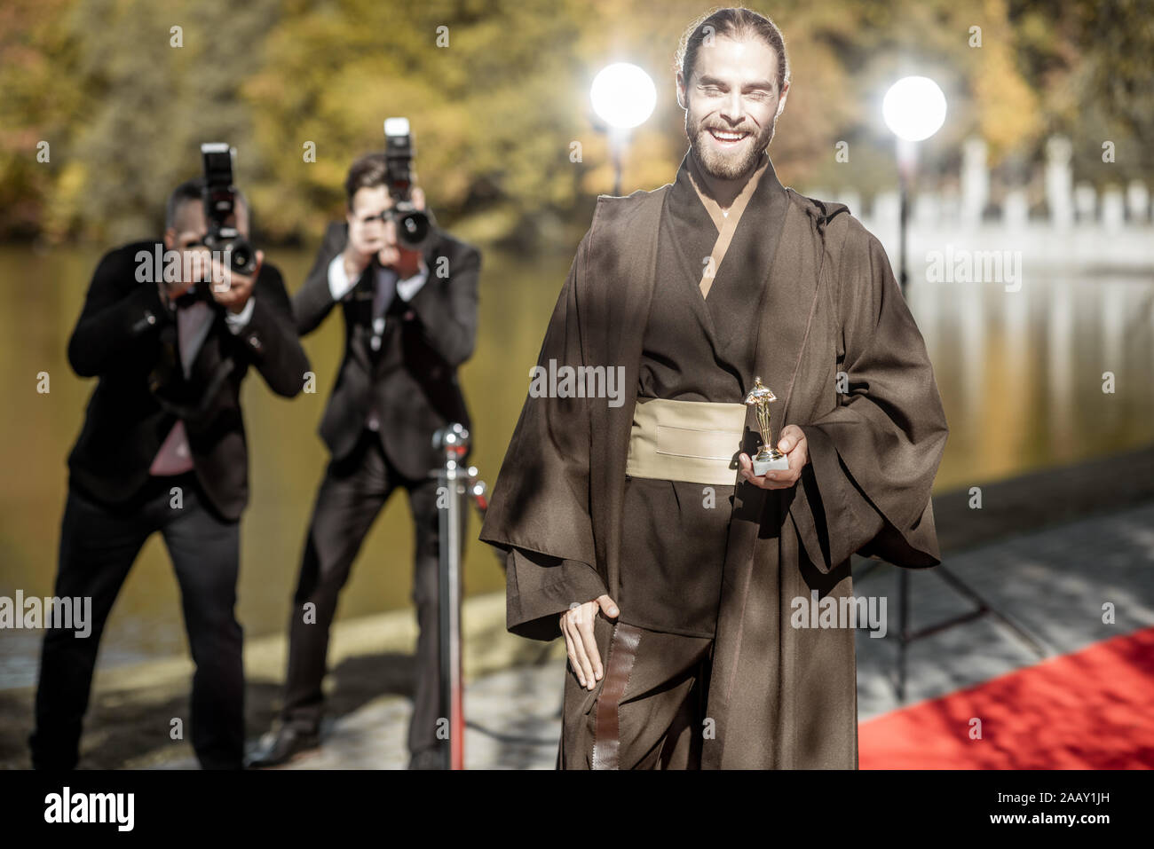 L'homme en costume comme un personnage de film bien connu à pied avec des reporters photo ennuyeux sur le tapis rouge lors de la cérémonie de remise des prix Banque D'Images