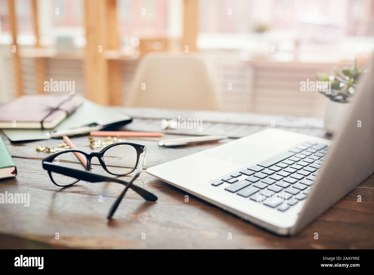 Image de fond de bureau d'affaires avec ordinateur portable et de l'offre sur un bureau en bois, l'accent sur disque noir lunettes rim en premier plan, copy space Banque D'Images