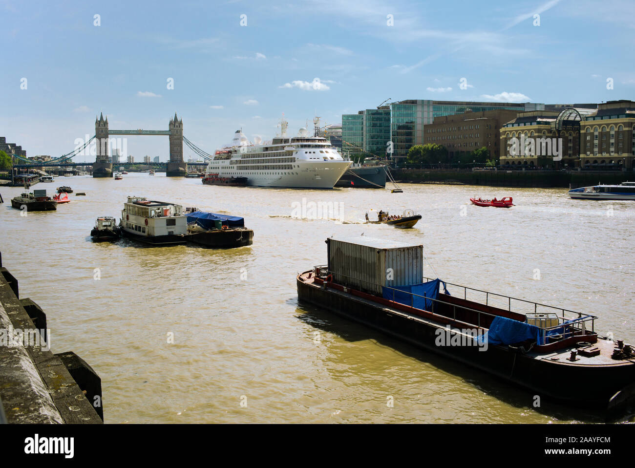 Une vue sur le Tower Bridge et la Tamise avec les barges et le navire amarré à côté du vent d'argent le HMS Belfast. Banque D'Images