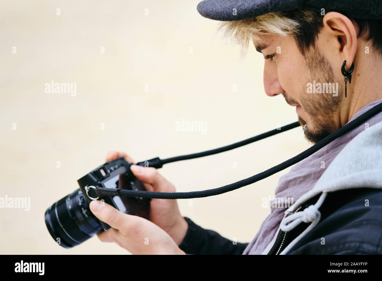 Hipster Photographe de rue l'examen de photos sur l'écran de l'appareil photo Mirrorless Banque D'Images