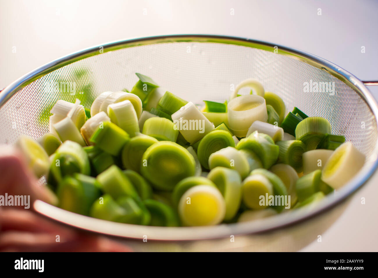 Tranches de poireau frais dans une passoire. En gros plan. Banque D'Images Tranches de poireau frais dans une passoire. En gros plan. Banque D'Images
