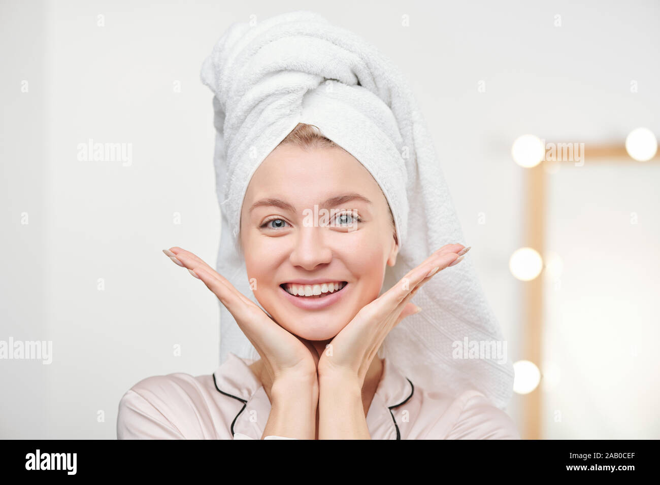 Jolie cheerful girl with towel on head apprécie sa peau saine Banque D'Images
