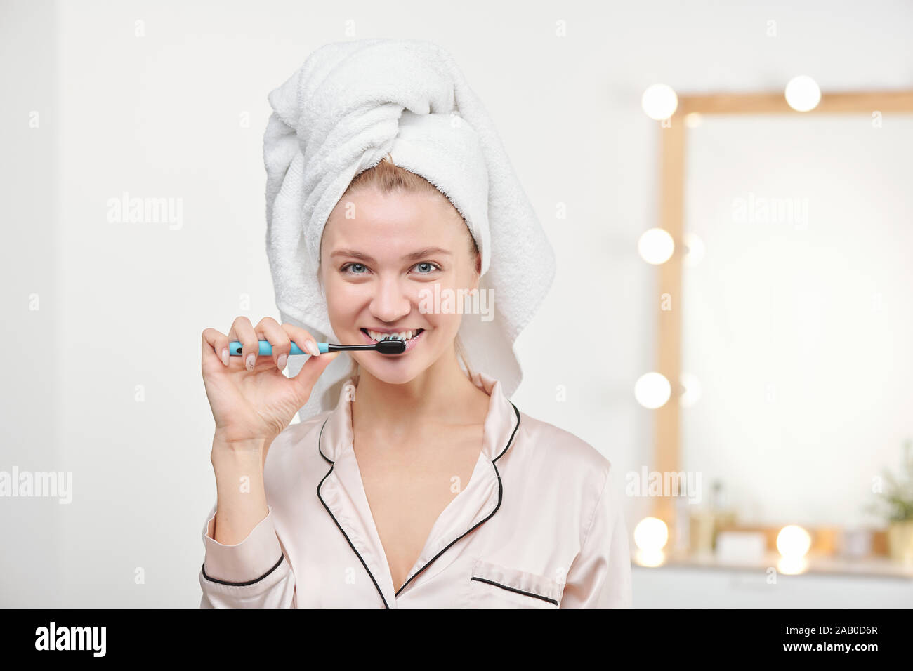 Jeune femme en bonne santé avec une brosse à dents se brosser les dents dans la salle de bains Banque D'Images