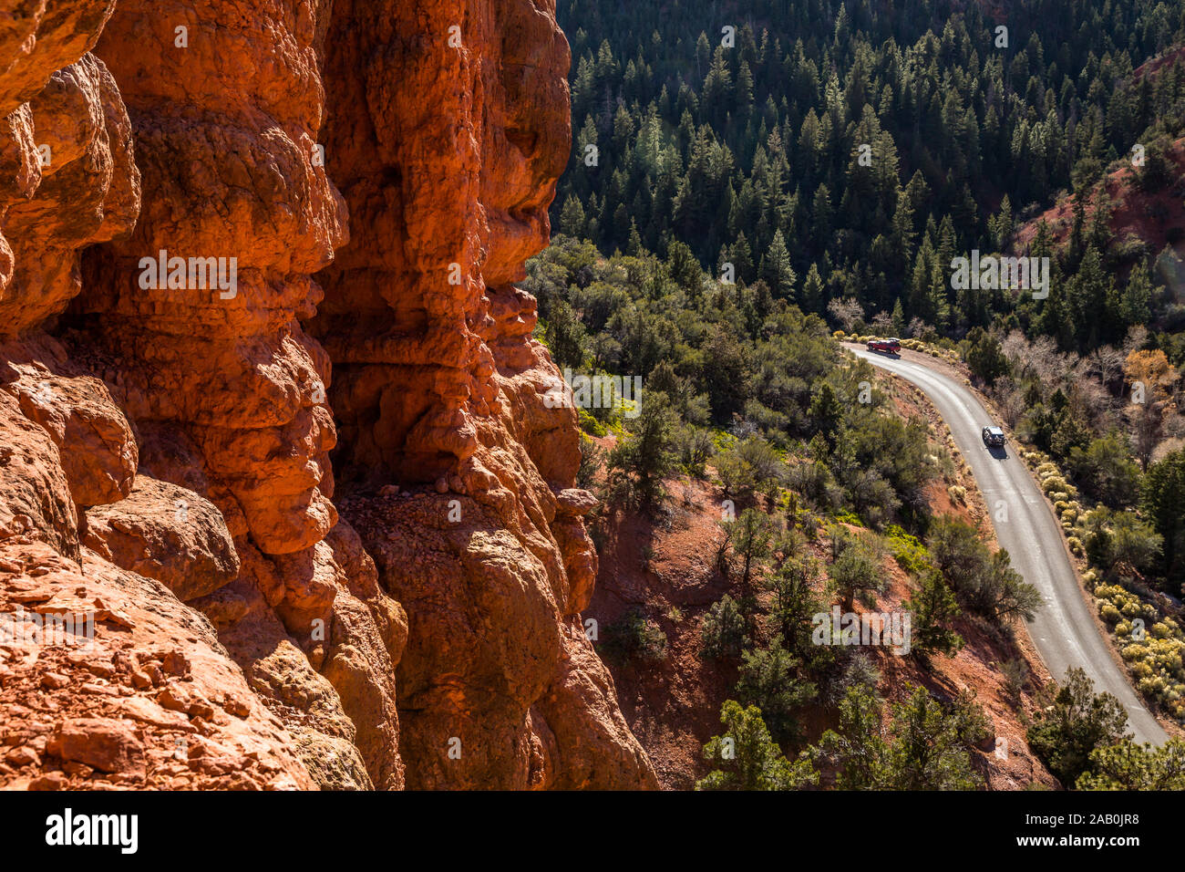 Depuis les tours de red rock canyon étroit à route avec deux camions de prendre la route jusqu'à la petit canyon dans l'Utah du sud sauvage. Banque D'Images