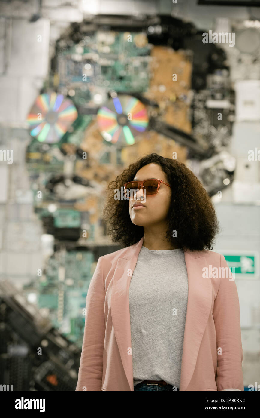 Jeune femme brune occasionnels dans les lunettes de soleil, t-shirt gris et rose Banque D'Images
