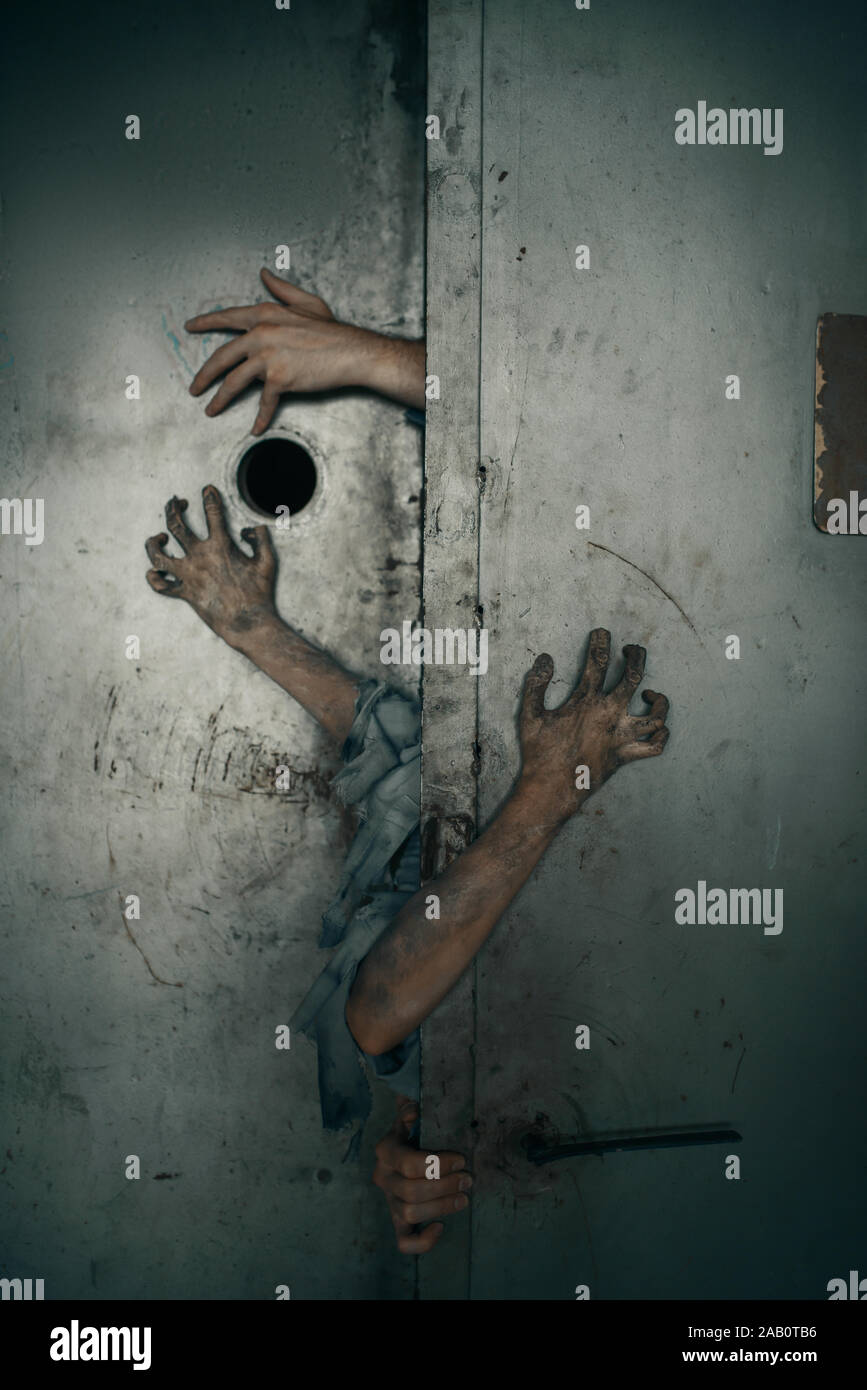 Les mains de Zombie qui dépasse de la porte de l'ascenseur Photo Stock -  Alamy