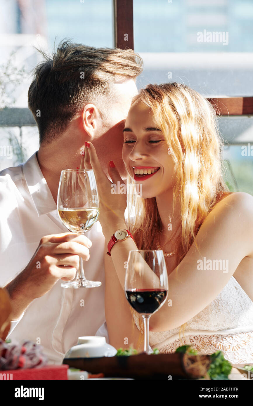 Laughting Happy young woman listening to ami chuchotant ses compliments et mots romantique Banque D'Images
