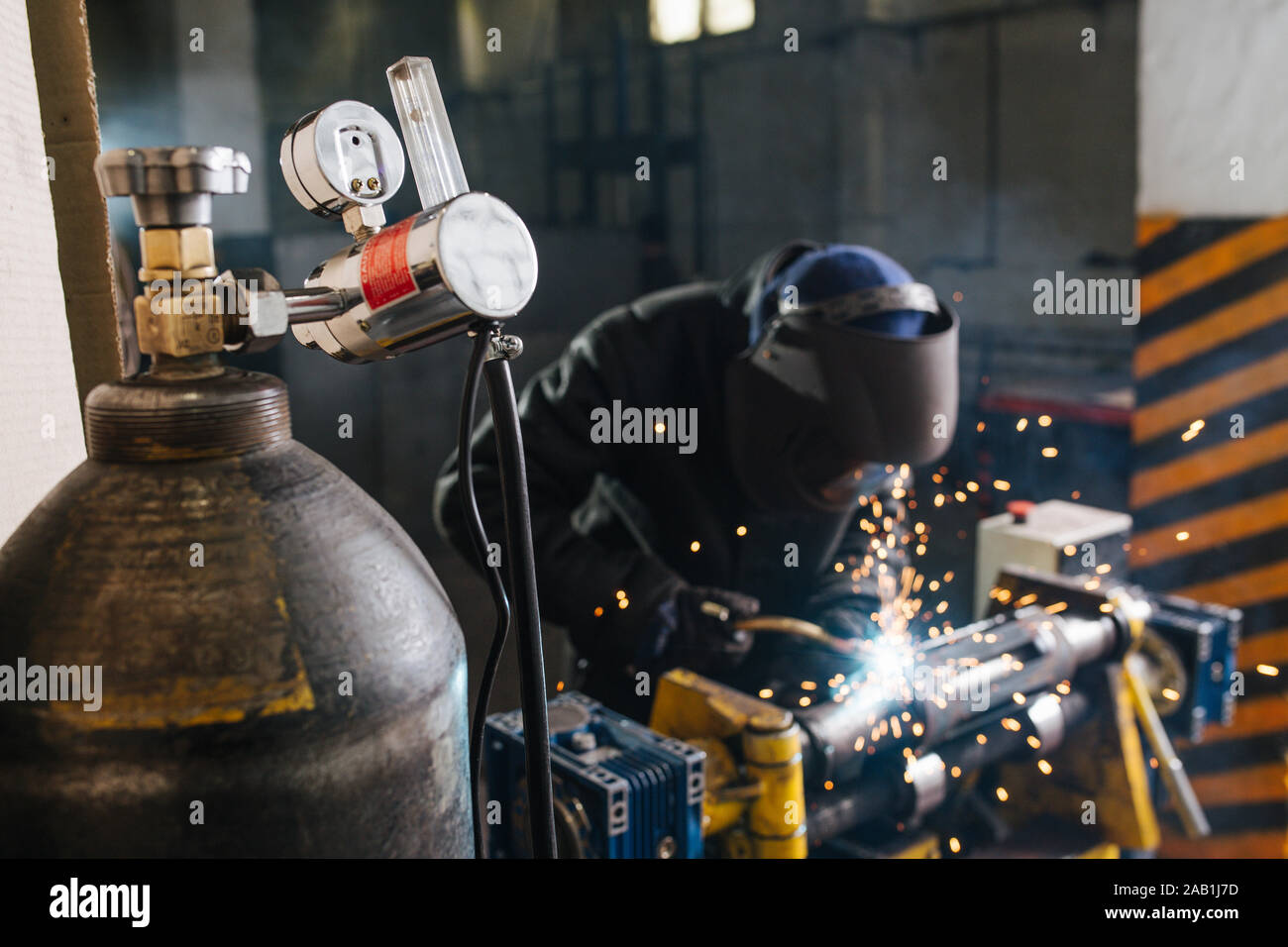 Morceau de métal à souder artisan, fixé avec du collier industriel à côté du réservoir d'oxygène Banque D'Images