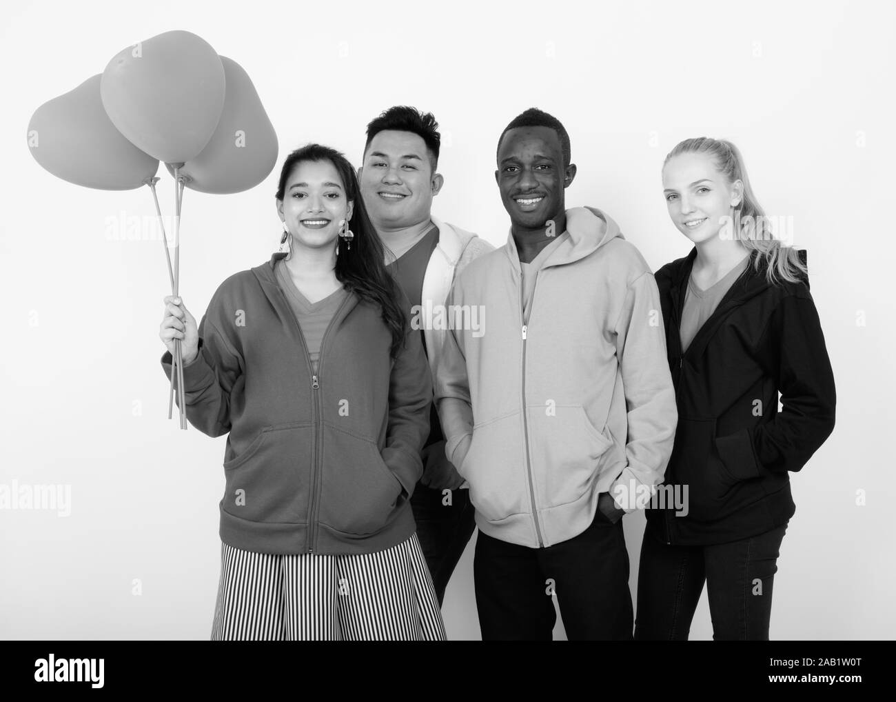 Studio shot of happy groupe diversifié de multi ethnic friends smiling together en maintenant le bouquet de ballons en forme de coeur rouge Banque D'Images