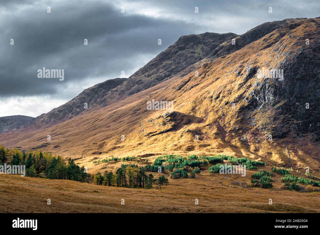 Faisceau de lumière du soleil hiting le flanc d'une montagne dans les Highlands écossais Banque D'Images