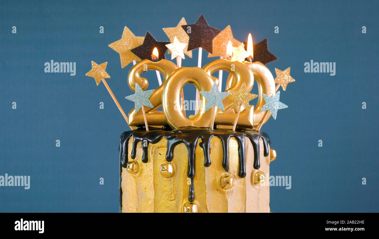 Happy New Year's Eve 2020 goutte d'or et noir sur un gâteau de fête, moderne et élégant, l'or bleu et blanc thème hiver table, Close up. Banque D'Images