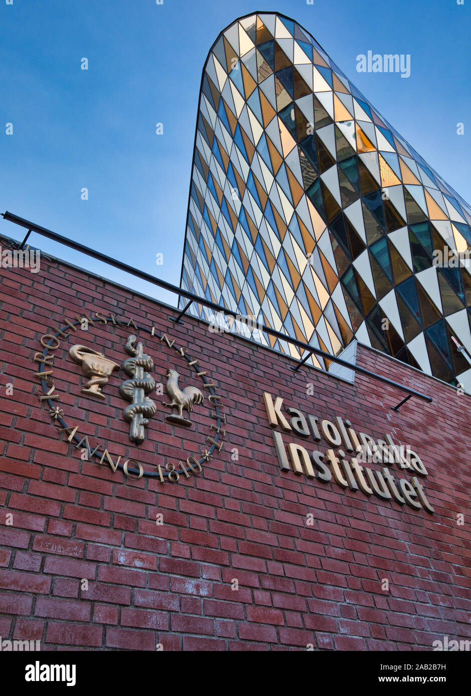 L'Institut Karolinska (Karolinska Institutet) signer et logo sur le mur avec l'Aula Medica auditorium verre derrière, Solna, Stockholm, Suède Banque D'Images