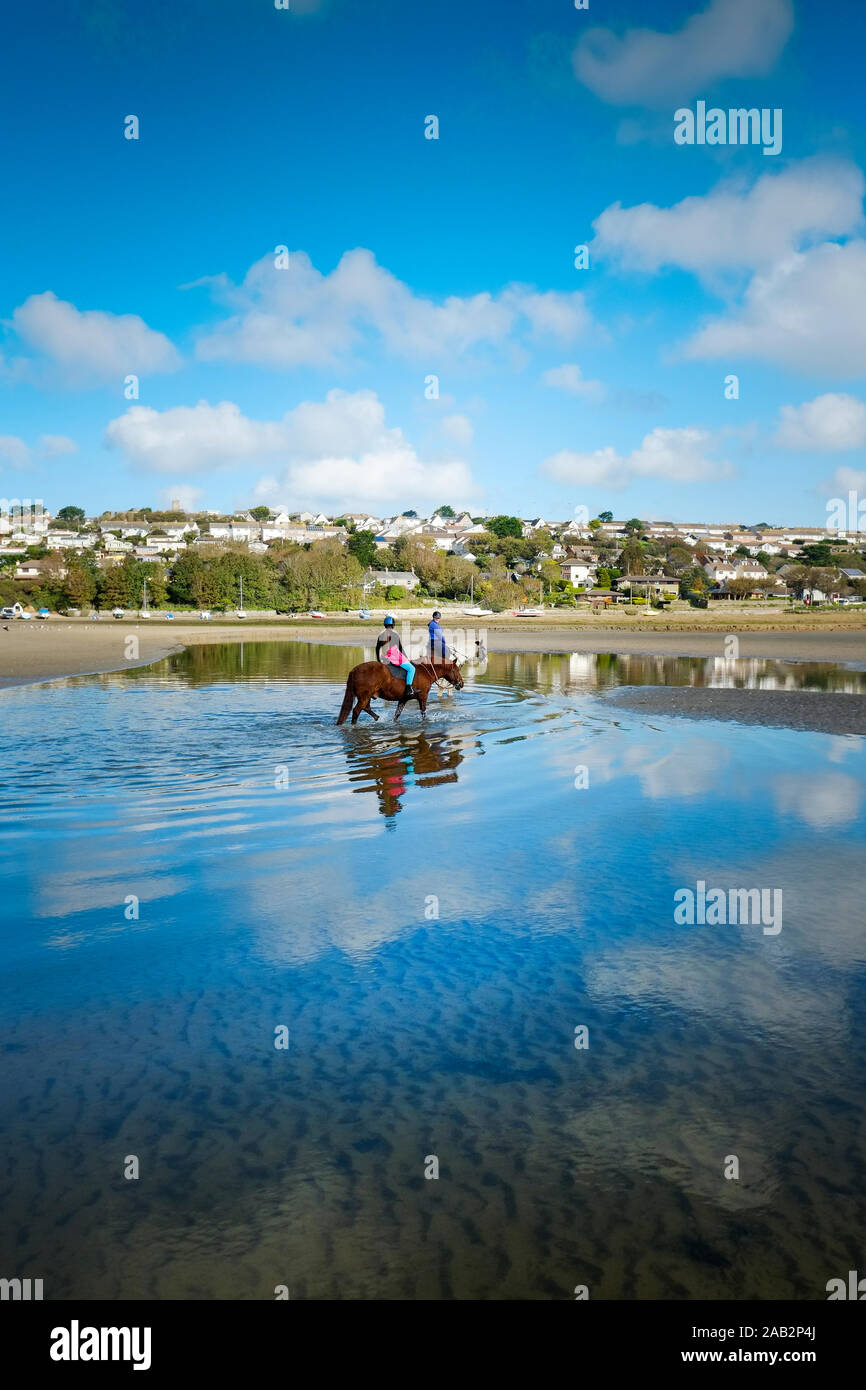 Promenades à cheval à marée basse sur l'estuaire Gannel à Newquay en Cornouailles. Banque D'Images