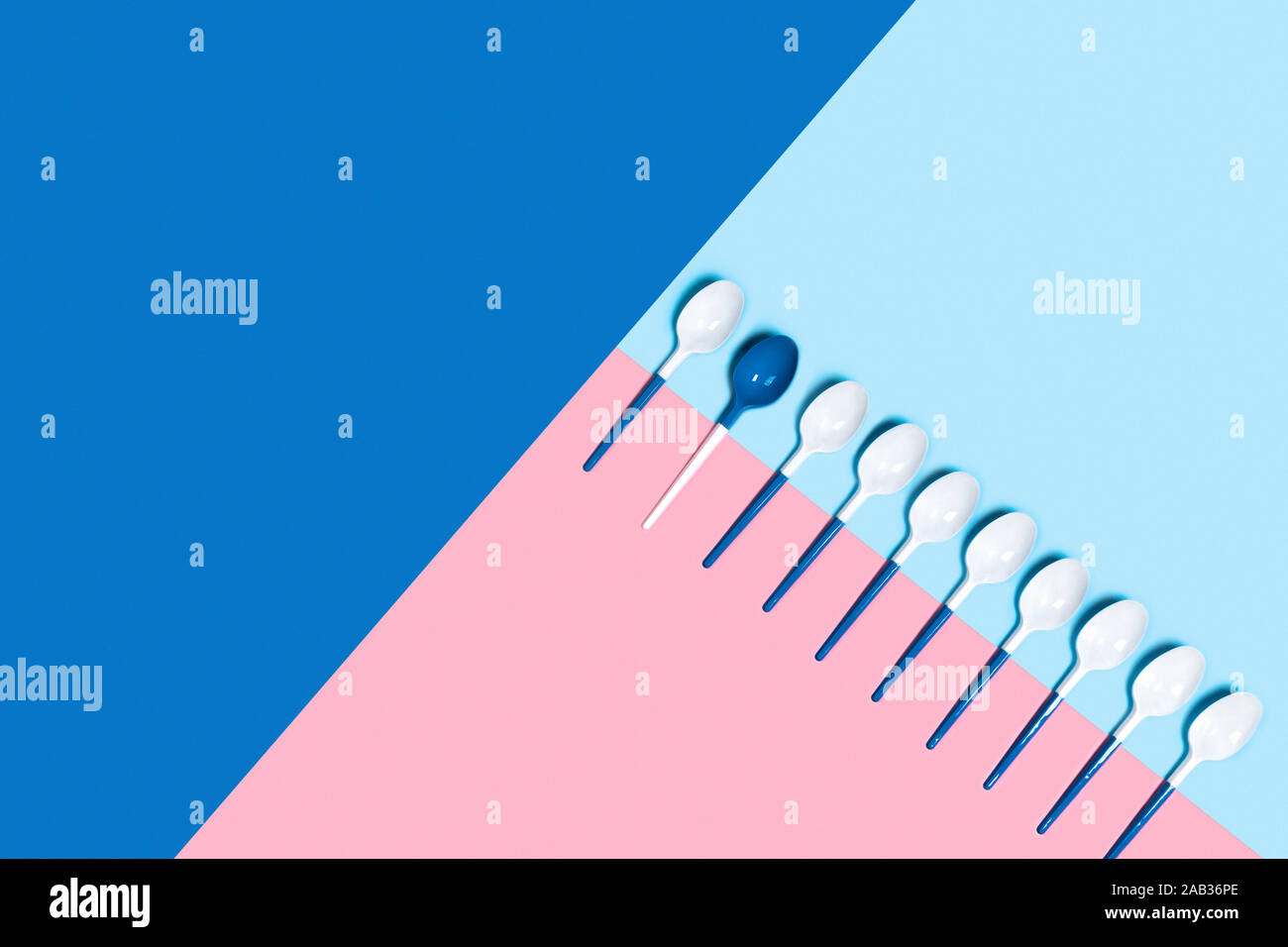 Concept de cuillères en plastique blanc bleu tricolore sur fond rose. Mise à plat, vue du dessus, copiez l'espace. Banque D'Images