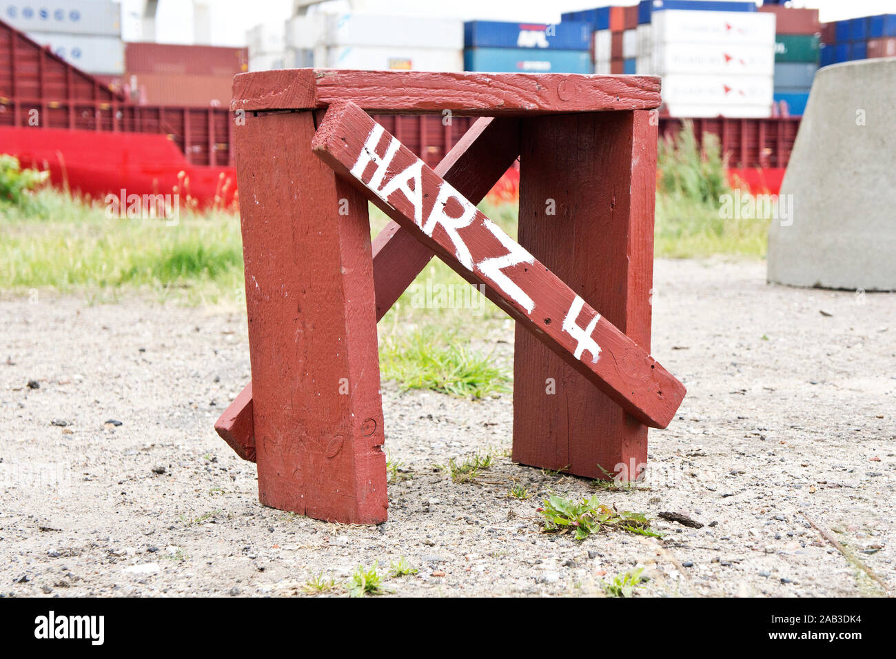 Ein selbst vor einem Containerschiff gezimmerter Hocker mit der Aufschrift "Harz" 4 |un tabouret en bois en face d'un porte-conteneurs avec le mot Banque D'Images