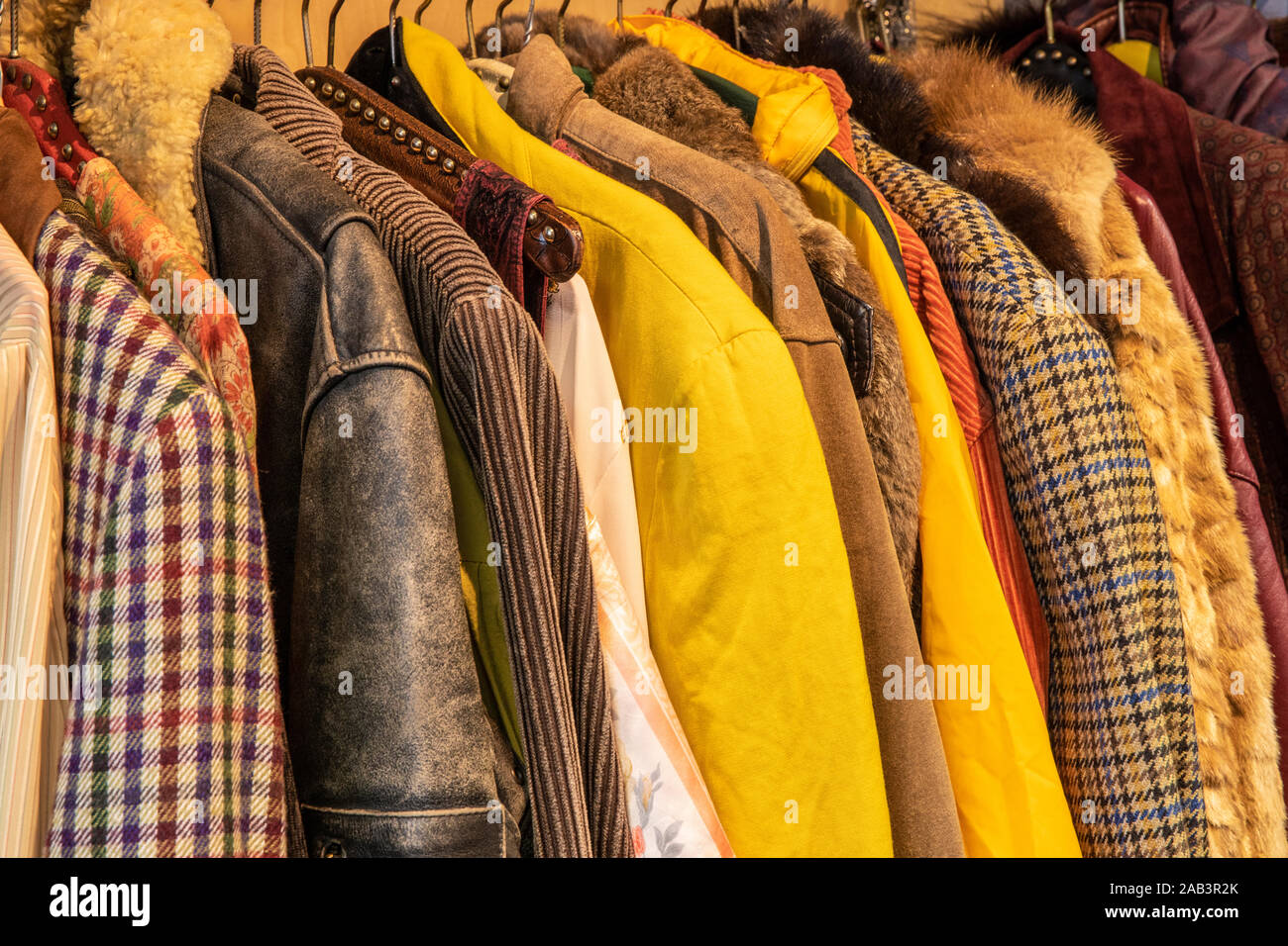Weda de couleurs jaune et marron vêtements vintage teinté, vestes avec différents motifs, couleurs et textures accroché sur un rack. Recylcing clothi Banque D'Images