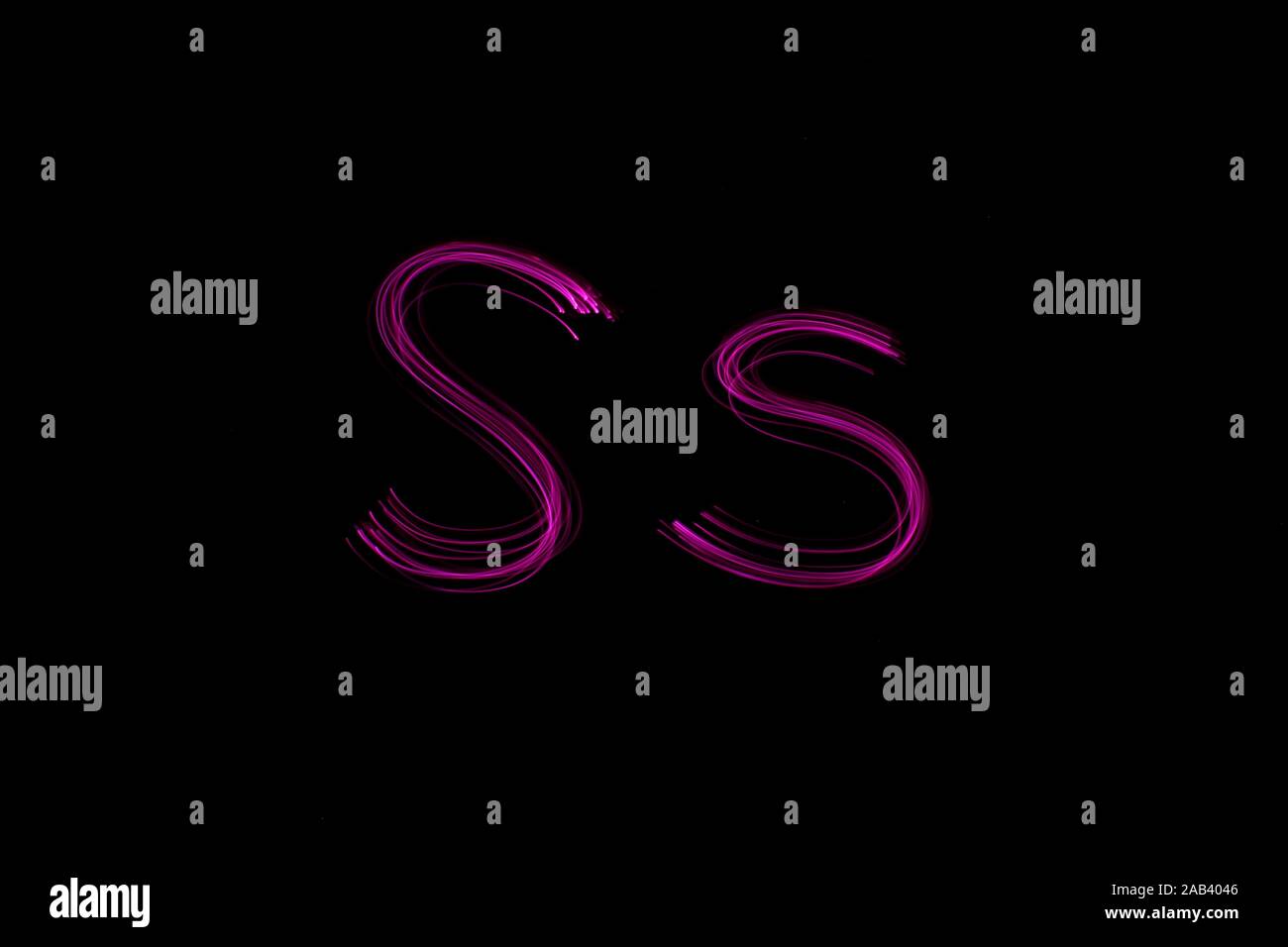 Une longue exposition photographie de la lettre s en couleur néon rose, en majuscules et minuscules, motif de lignes parallèles sur un fond noir. Banque D'Images
