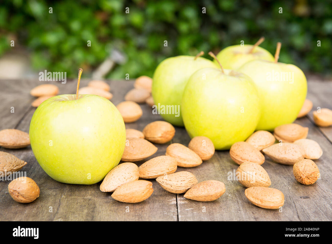 Äpfel und Mandeln liegen im Holztisch zusammen auf einem Garten |pommes et amandes couché ensemble sur une table en bois dans le jardin| Banque D'Images