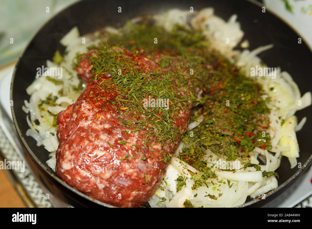 Hacher la viande hachée à l'oignon et les légumes secs à l'aneth avec des épices dans une poêle de la cuisine maison. Processus de cuisson. Banque D'Images