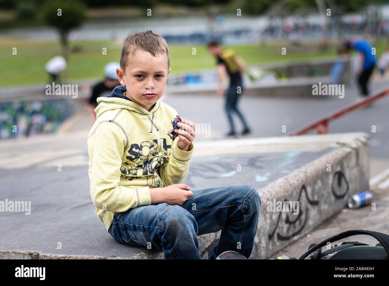 Un mignon petit garçon avec TDAH, l'autisme, du syndrome d'Asperger équitation autour du skatepark, de refroidissement et d'avoir du plaisir tout en s'exerçant et libération d'énergie Banque D'Images