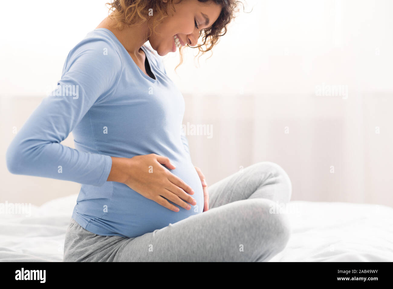 Heureux femme enceinte toucher ventre, side view Banque D'Images