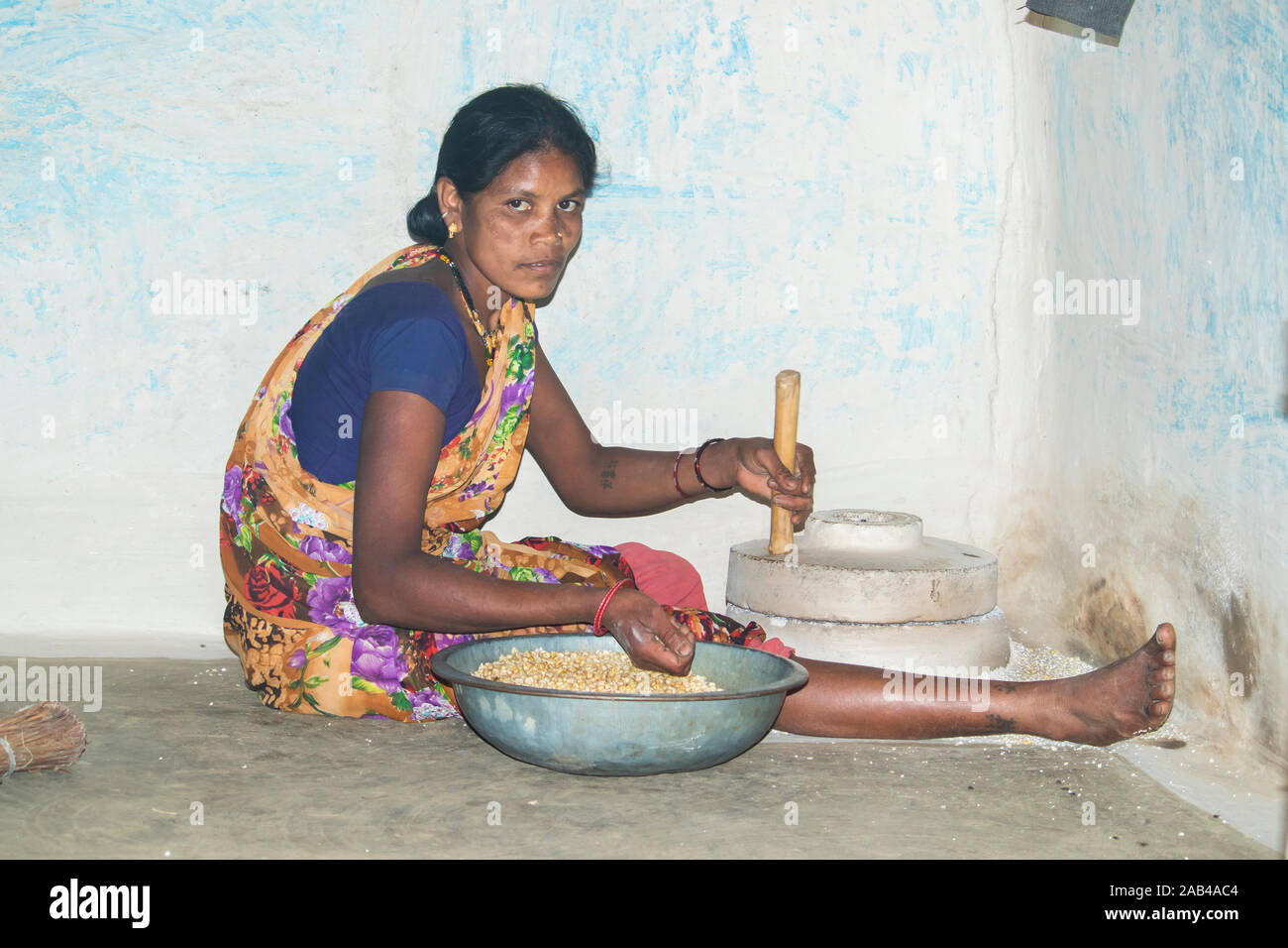 Sijhora, Madhya Pradesh, Inde- Novembre 2019 : femme de l'Inde rurale, utiliser l'moulin pour moudre le maïs dans Sijhora le Madhya Pradesh en Inde. Banque D'Images