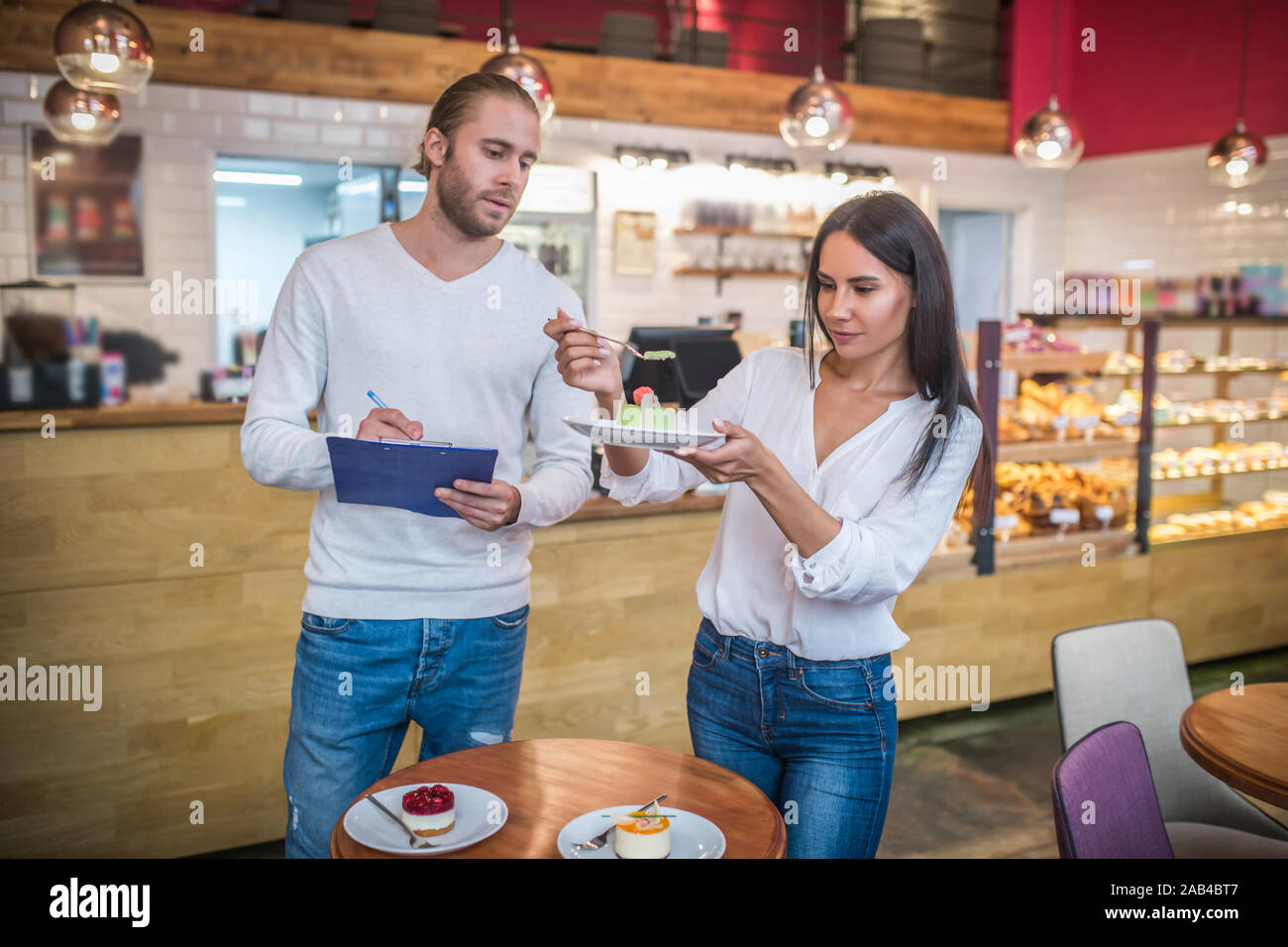 Couple propriétaire d'une cafétéria d'essayer les desserts menu est en cours de composition Banque D'Images