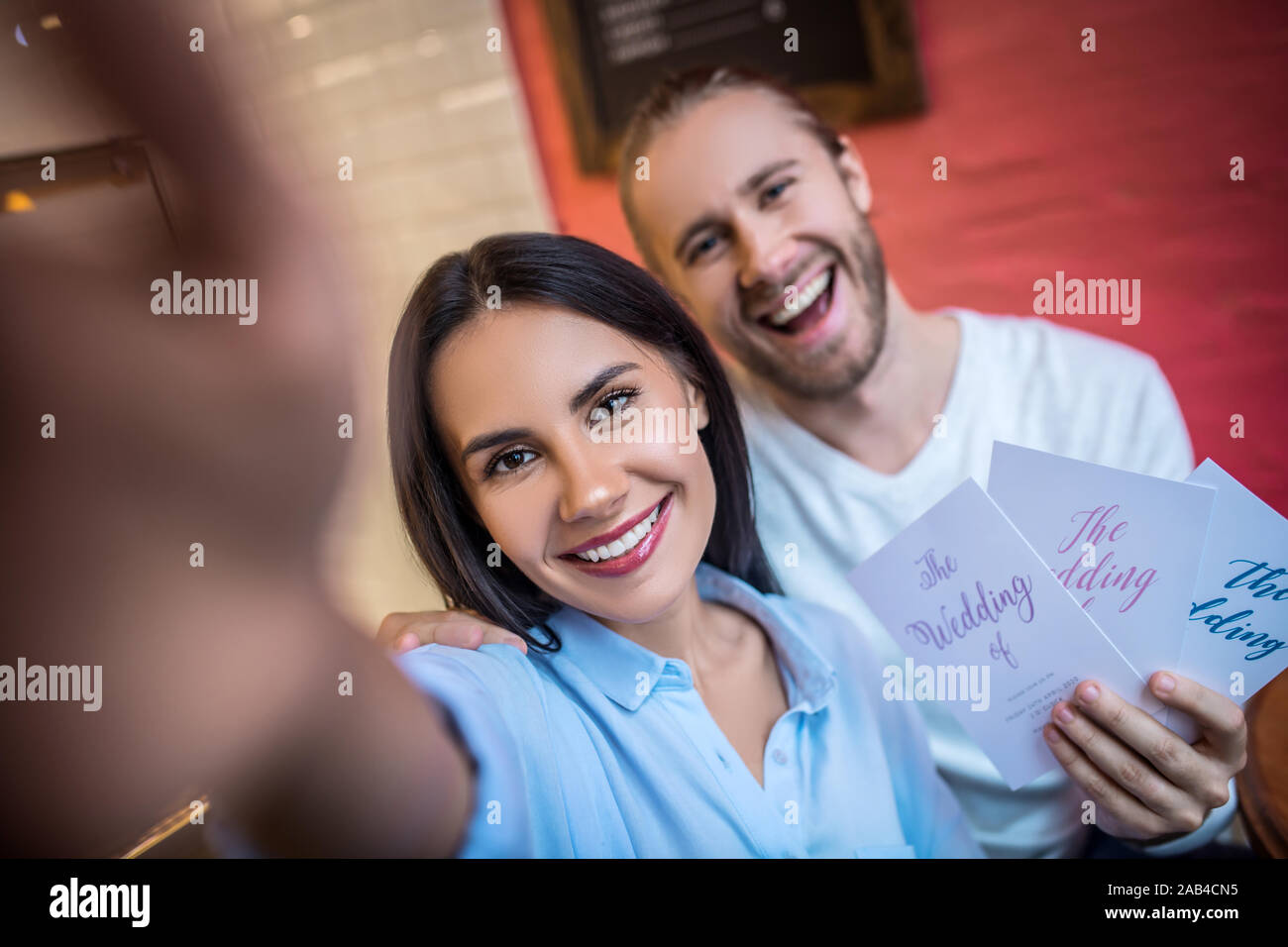 Faire amie avec selfies futur mari holding wedding invitations Banque D'Images