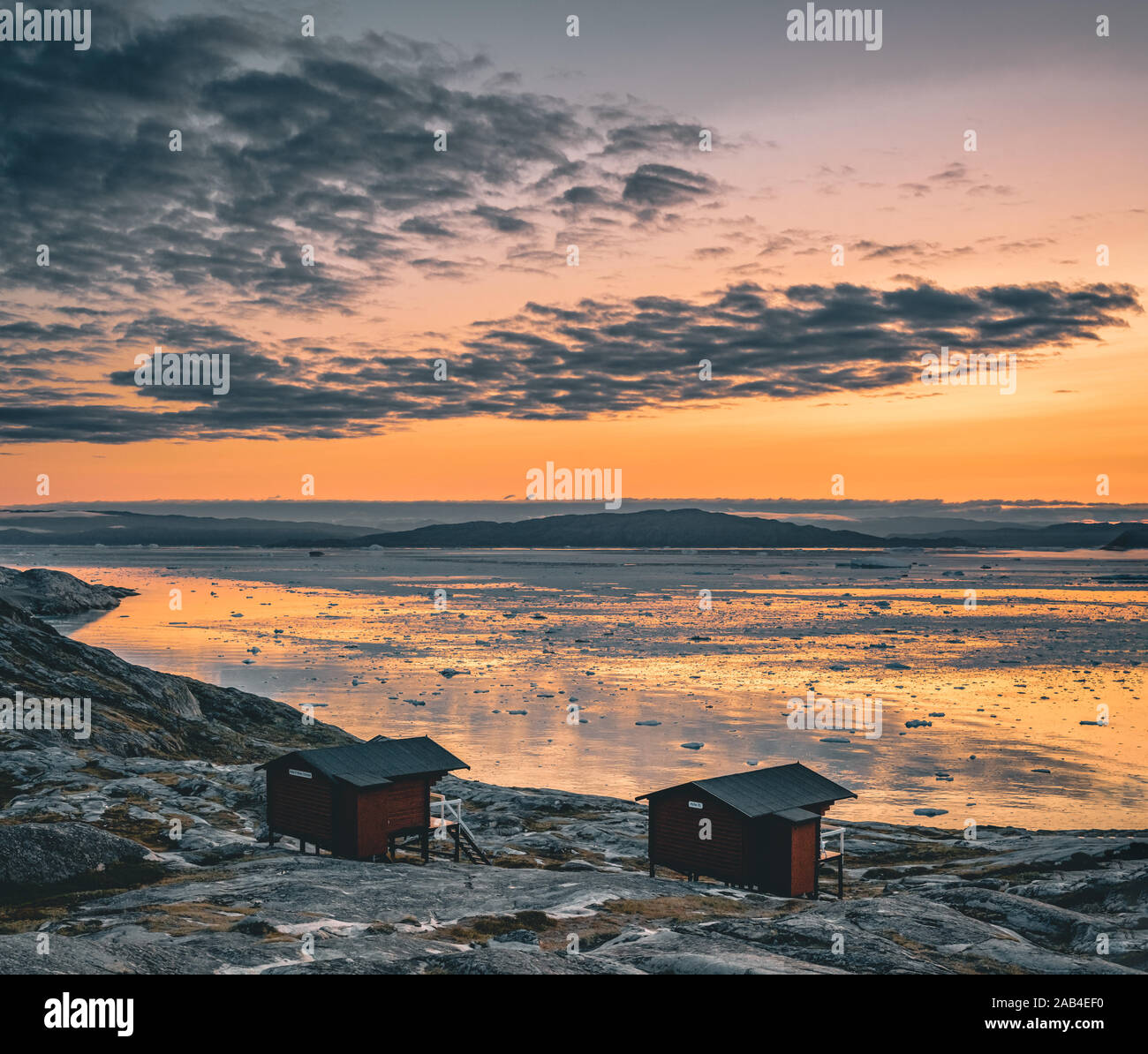 Image panoramique de la Camp Eqi Glacier Eqip Sermia à au Groenland. nature paysage avec lodge cabines. Soleil de minuit et ciel rose. Destination touristique Banque D'Images