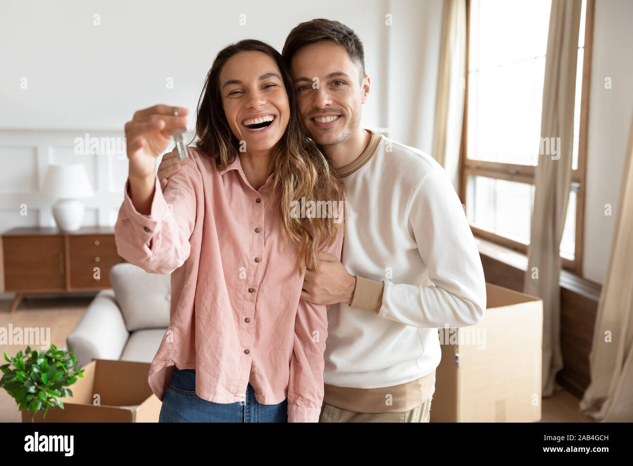 Heureux couple holding clé de nouvelles accueil le jour du déménagement Banque D'Images