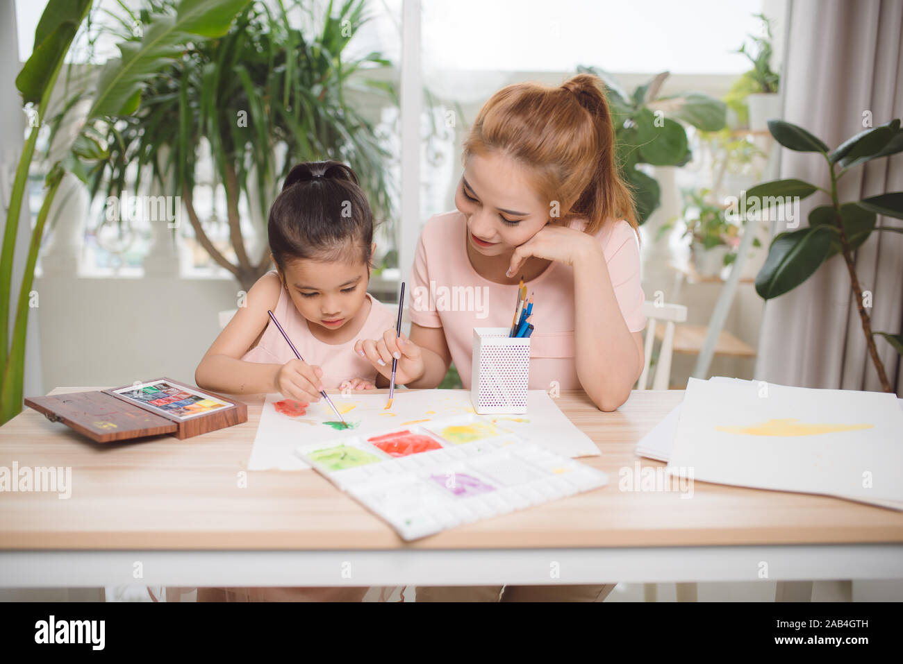 Jeune asiatique belle maman avec sa fille peinture pour enfants à la maison. Banque D'Images