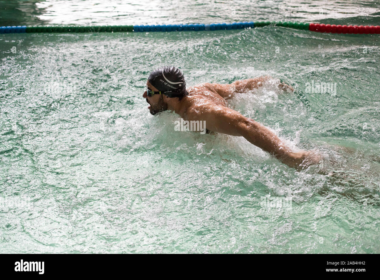Homme natation sur une piscine intérieure. Banque D'Images
