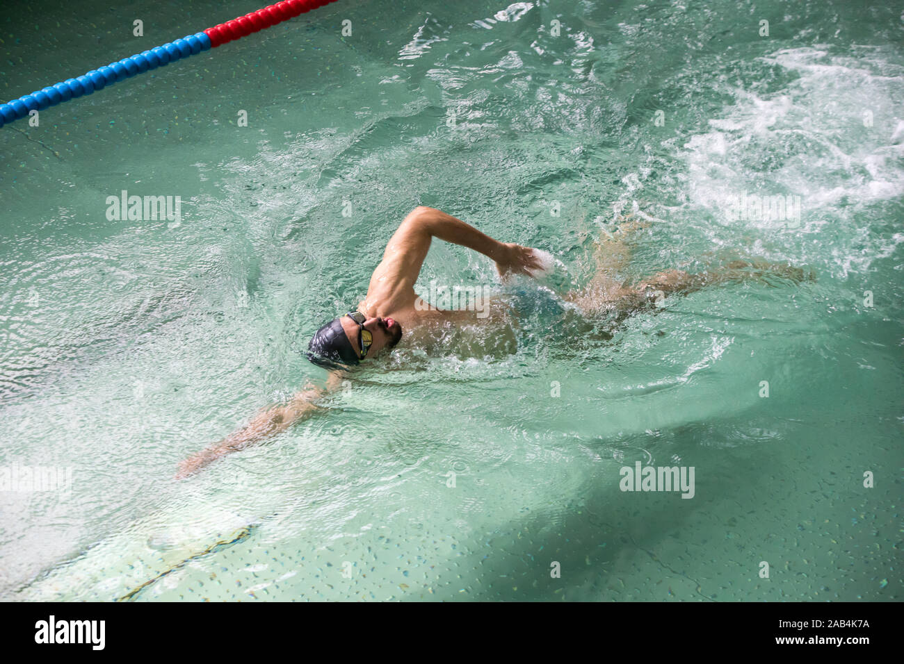 Homme natation sur une piscine intérieure. Banque D'Images