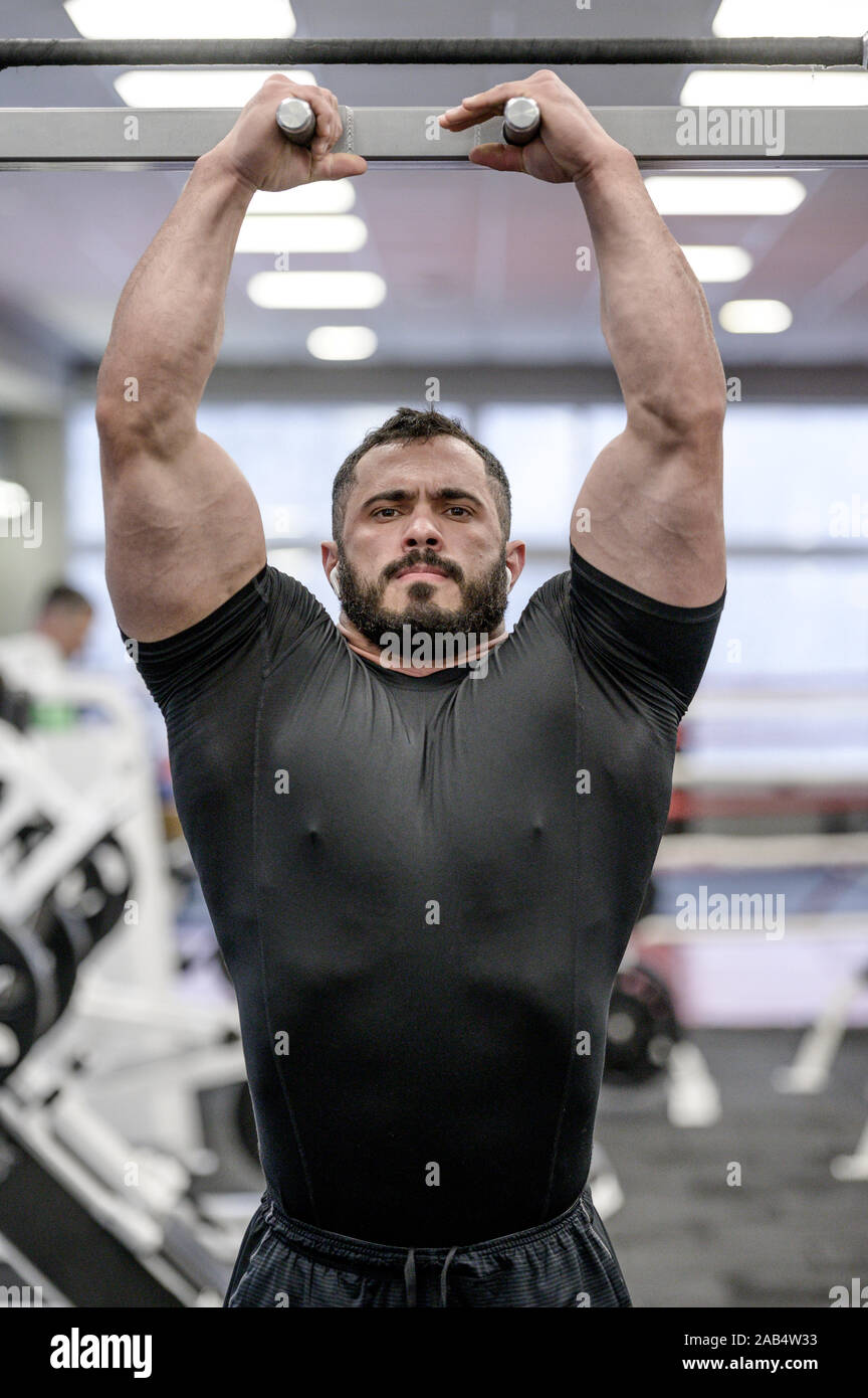 Physique athlétique jeune homme barbu en tenue de sport noir barre  horizontale prépare à tirer vers le haut dans le sport fitness musculation  Photo Stock - Alamy