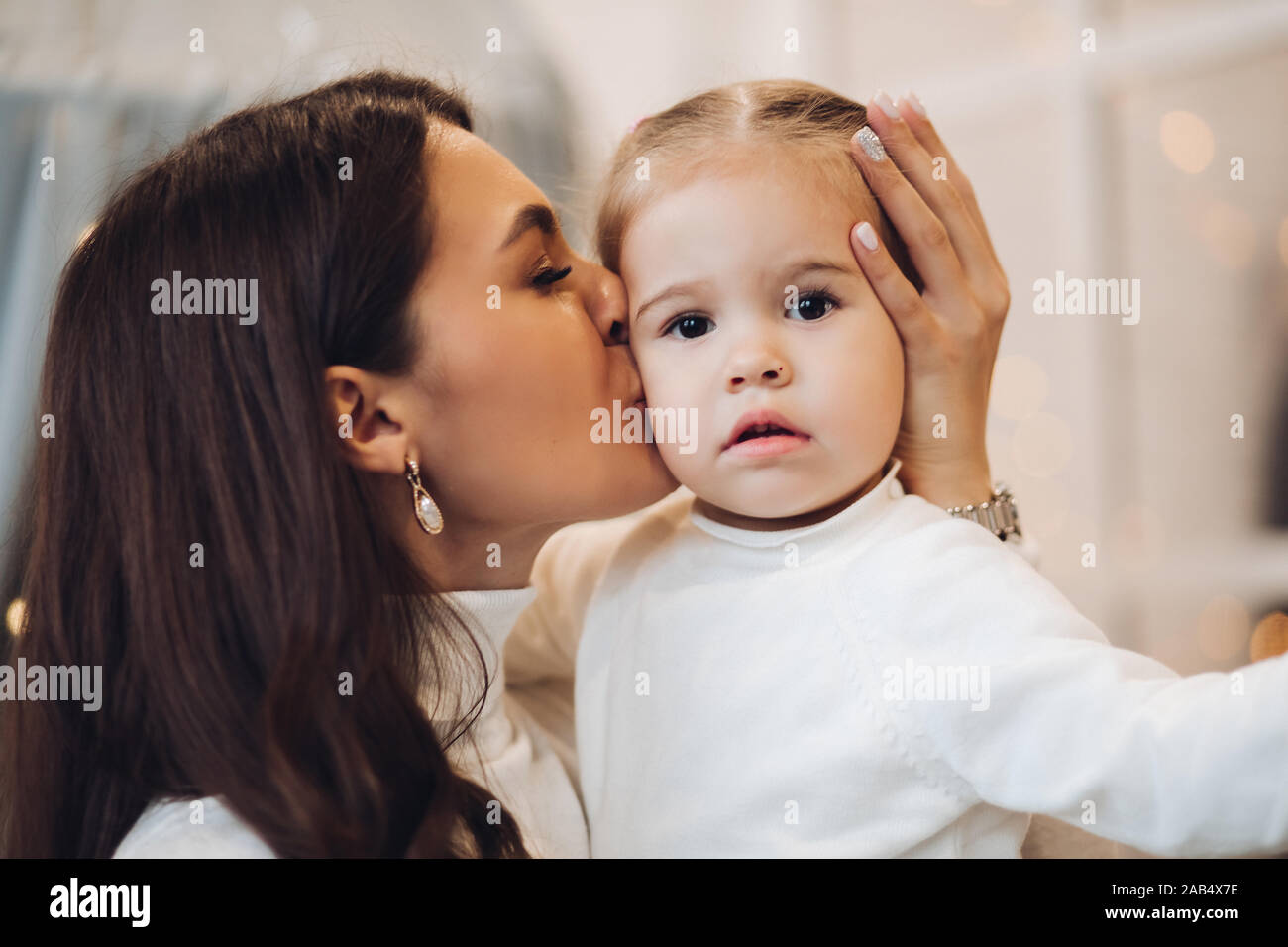 Mère embrassant sa fille en joue. prix Décorées pour Noël. Banque D'Images