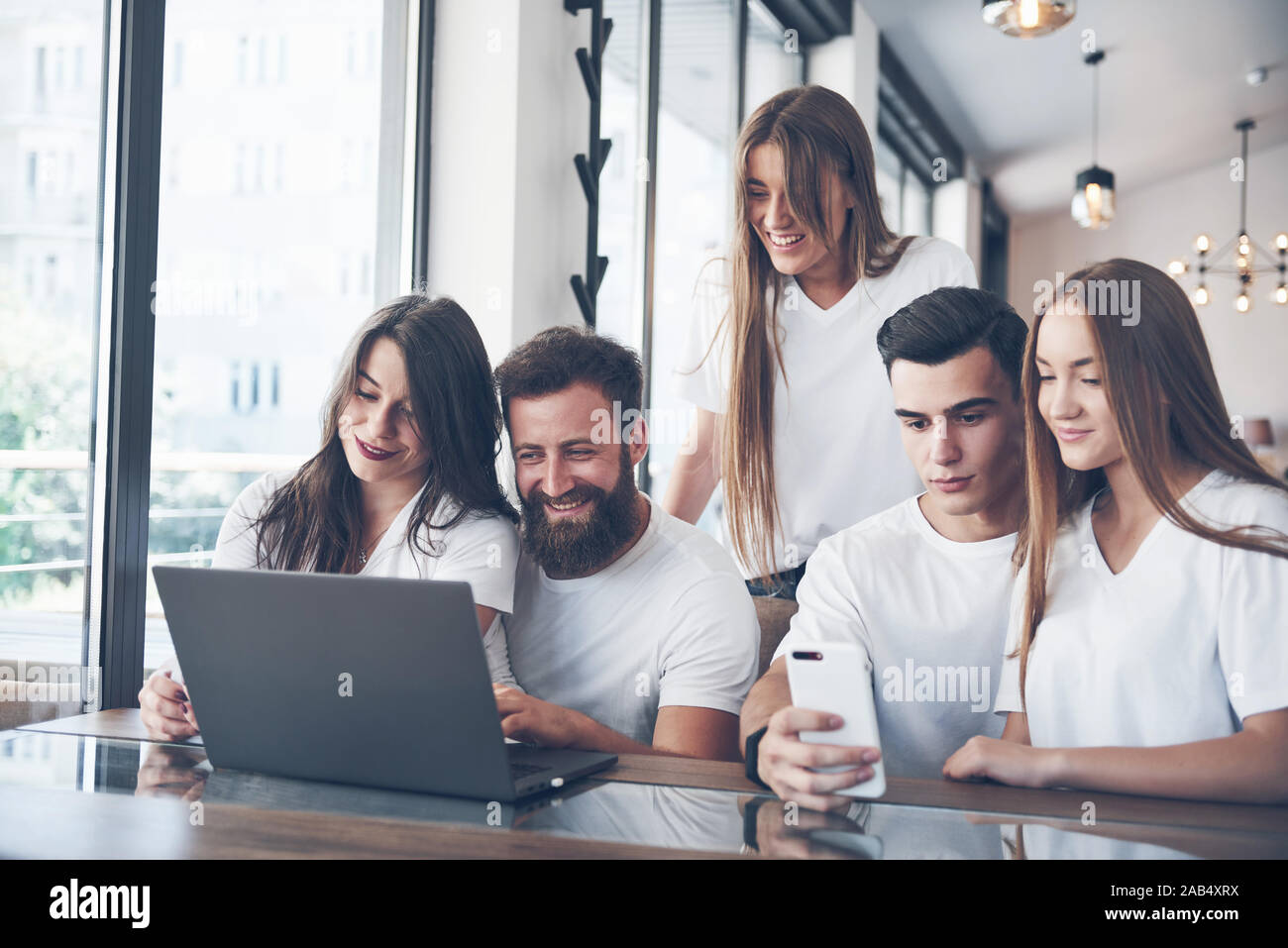Un groupe de jeunes avec des gadgets et un ordinateur portable organiser une séance de brainstorming et de communiquer les uns avec les autres. Le concept de l'élaboration d'une jeune entreprise Banque D'Images