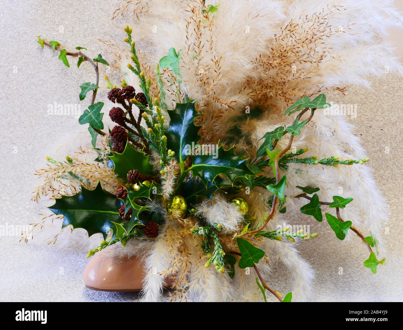 Arrangement de Noël houx, lierre et l'herbe de la pampa dans une chaussure vue avant Banque D'Images