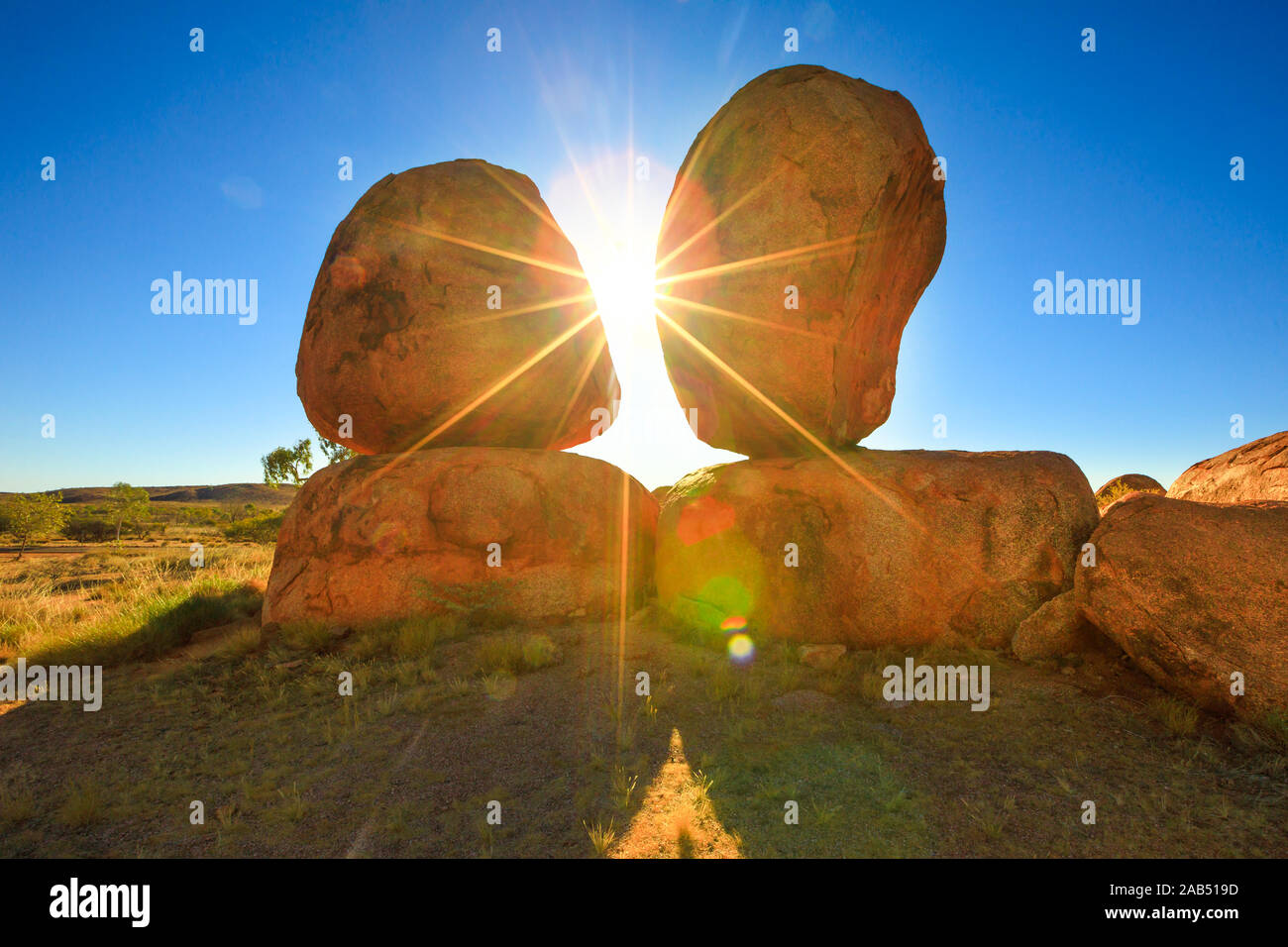 L'Australie, Territoire du Nord. Les terres autochtones au centre rouge. Ciel de soleil au lever du soleil derrière l'emblématique des Œufs de serpent mythique à Karlu Banque D'Images