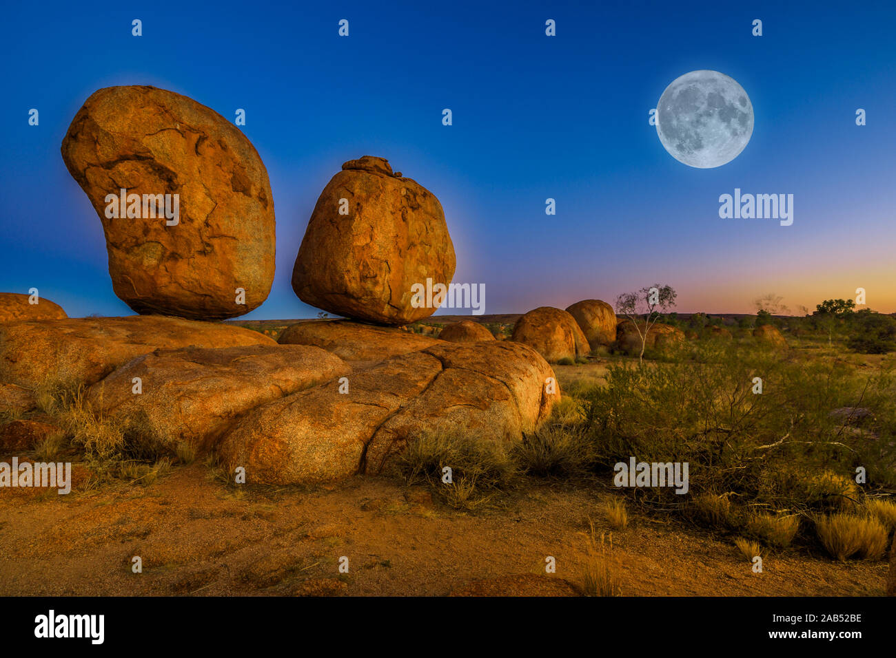 Devils Marbles emblématique : les oeufs de serpent mythique avec pleine lune sur ciel crépusculaire. Karlu Karlu est l'une des merveilles naturelles les plus célèbres Banque D'Images