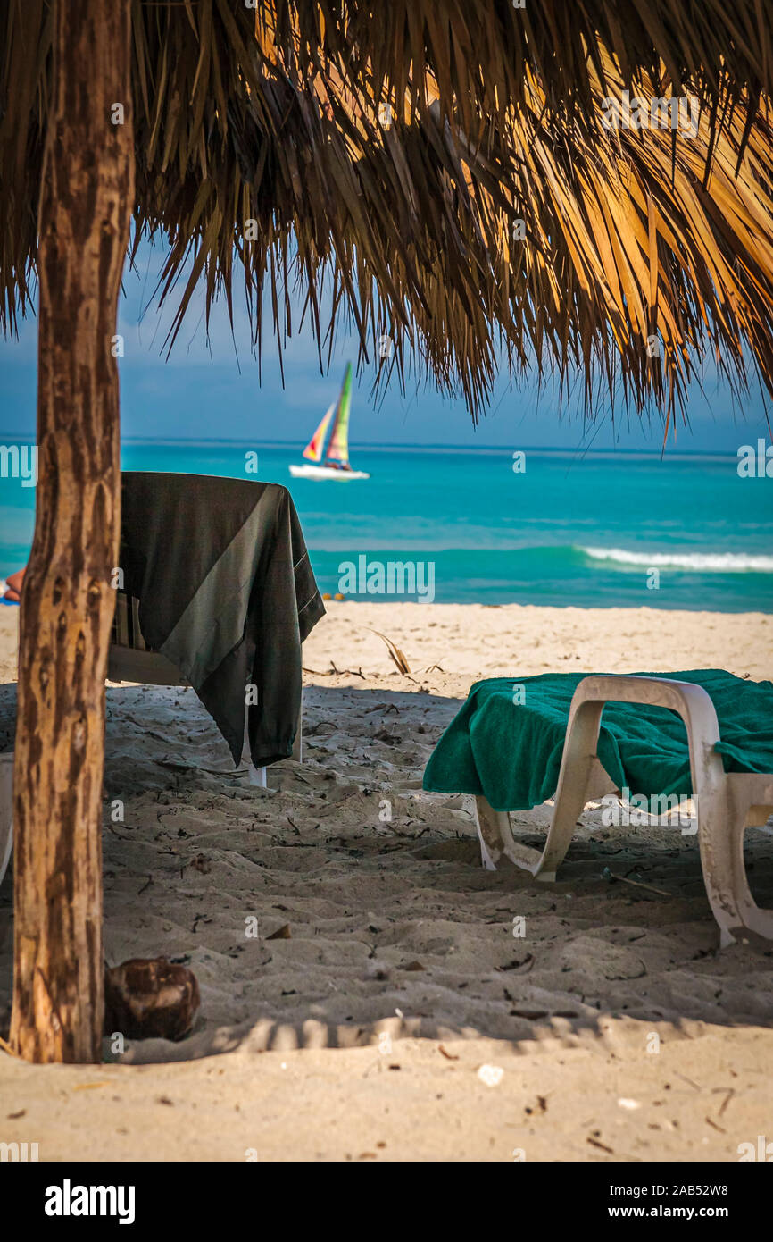 Chaises de plage et serviette sous un abri de paille sur la plage de Varadero, Cuba Banque D'Images