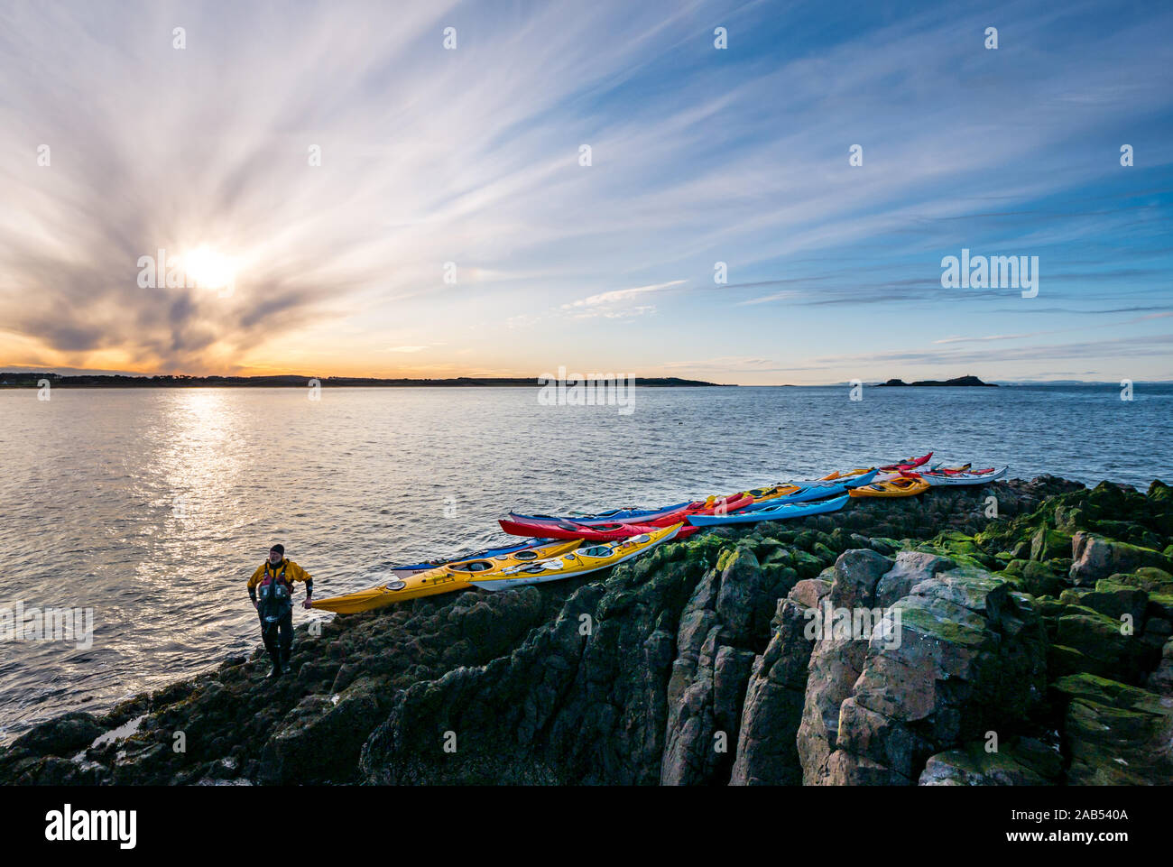 Lothian Club de kayak de mer sur le rivage avec des kayaks au coucher du soleil, l'île d'agneau, Firth of Forth, Ecosse, Royaume-Uni Banque D'Images