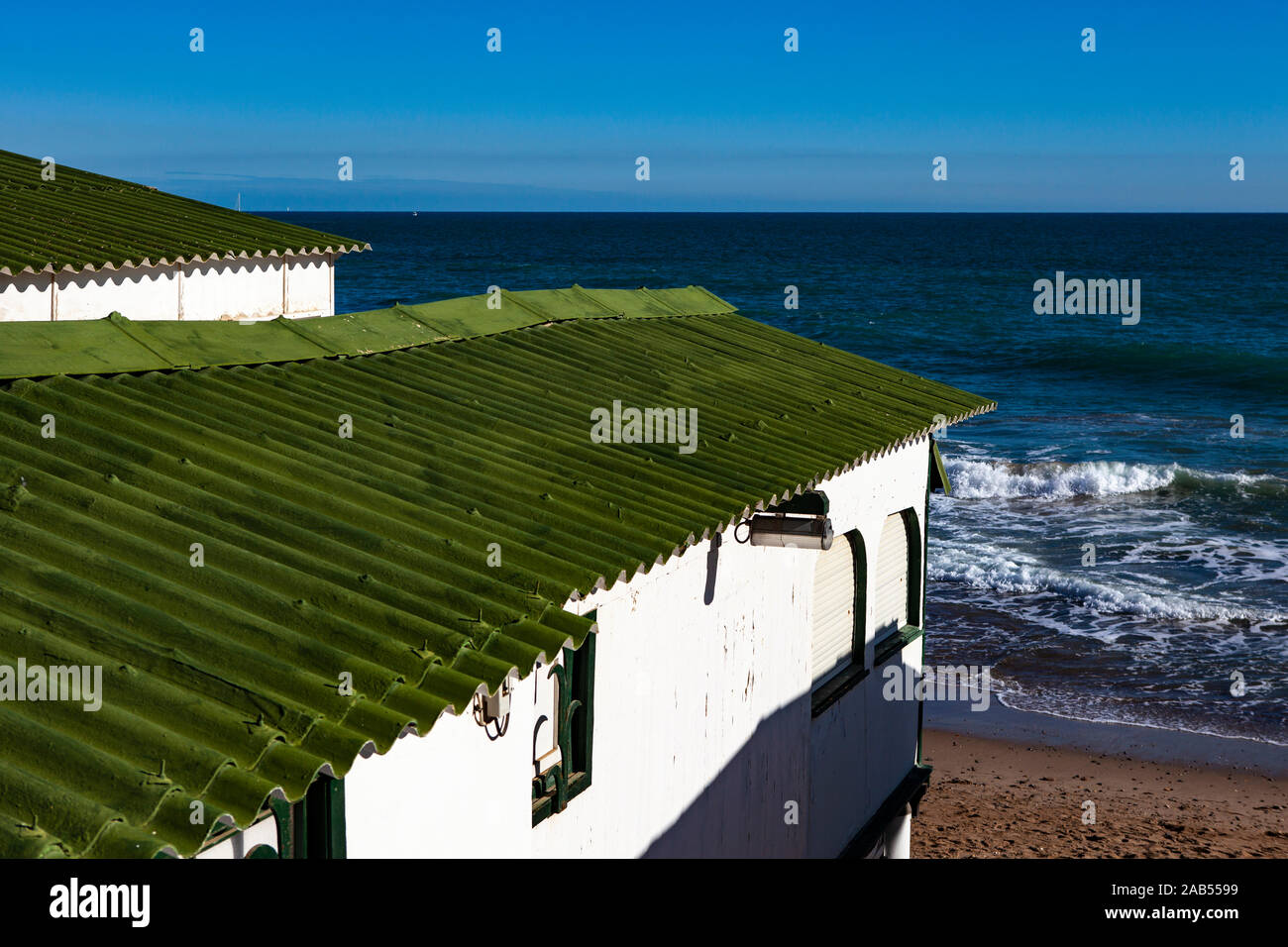 Platja de Les Casetes del Garraf, Garraf, Barcelone, Catalogne. Ces petites maisons de plage vert et blanc sont dans le village balnéaire de Garra Banque D'Images