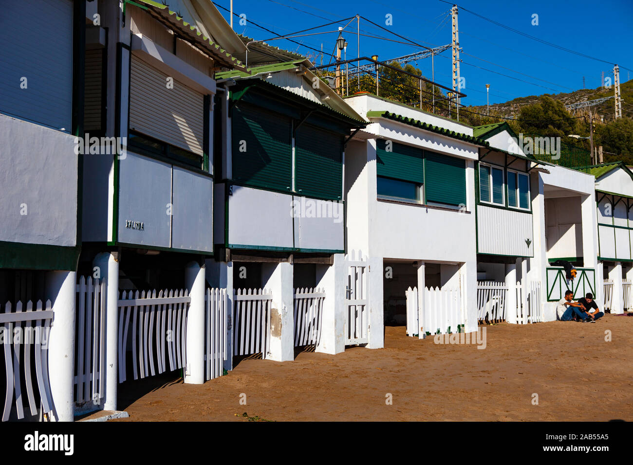 Platja de Les Casetes del Garraf, Garraf, Barcelone, Catalogne. Ces petites maisons de plage vert et blanc sont dans le village balnéaire de Garra Banque D'Images