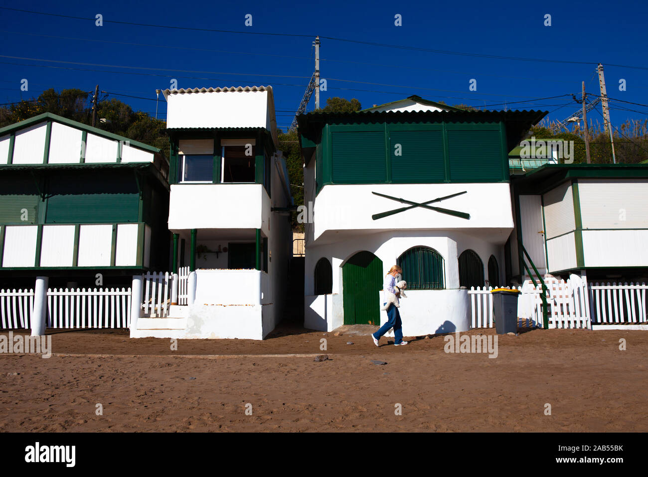 Platja de Les Casetes del Garraf, Garraf, Barcelone, Catalogne. Ces petites maisons de plage vert et blanc sont dans le village balnéaire de Garra Banque D'Images