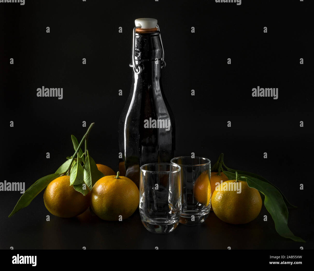 Arrière-plan avec bouteille d'alcool, de verres et de tangerines Banque D'Images