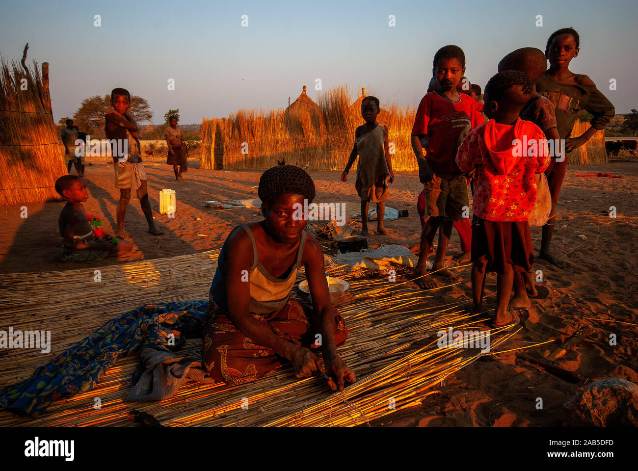 Habitants de la bande de Caprivi, femme la construction d'un mur en paille pour sa maison, en Namibie Banque D'Images